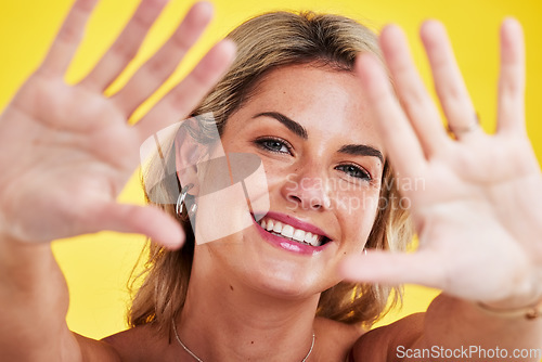 Image of Fashion, frame and portrait of woman with hands on yellow background in makeup, natural cosmetics and style. Beauty, happiness and face of female person with palms up, confidence and happy in studio