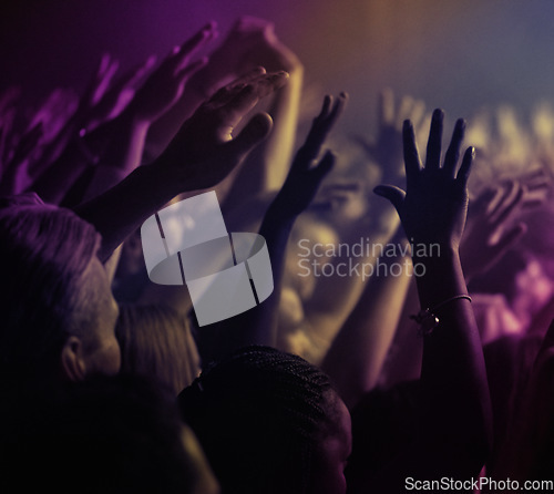 Image of Hands, lights and people at rock concert or music festival with neon lighting, energy and dancing at live event. Dance, fun and group of excited fans in arena at band performance or crowd at party.