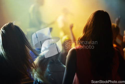 Image of Music concert, crowd and people singing at night performance for gen z festival with party lights, dancing and cheers. Rock band on stage at event and crowd dance, audience rear or women fans