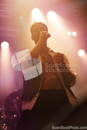 Image of Concert, music and singer with man on stage for night, festival and rock performance. Spotlight, karaoke and band with male artist singing in show for musician, clubbing and disco party event