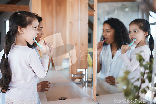 Image of Brushing teeth, girl and mom with dental cleaning and mirror in a bathroom. Mother, kid and smile of wellbeing and wellness with learning of health care and toothbrush in the morning at home