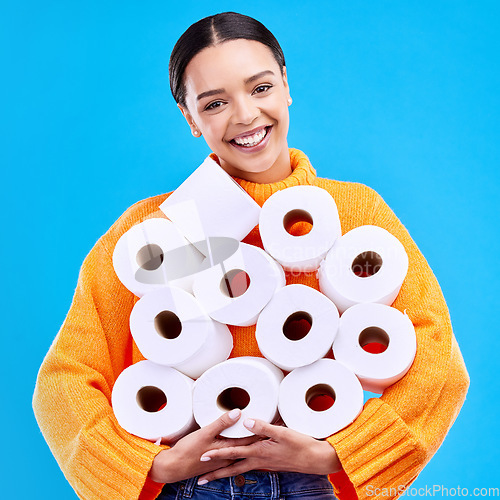 Image of Toilet paper, young woman and portrait with happiness and smile in a studio. Isolated, blue background and happy female person and youth model with tissue rolls stock and gen z fashion smiling