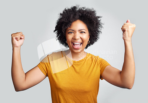 Image of Portrait, winner and wow with a woman in studio on a gray background celebrating a victory or success. Motivation, smile and celebration with a happy young female model cheering her own achievement