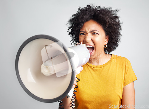 Image of Megaphone, speech and angry woman in studio for message, broadcast or screaming for freedom. Speaker, microphone and girl protest for change, democracy or justice or womens rights on grey background