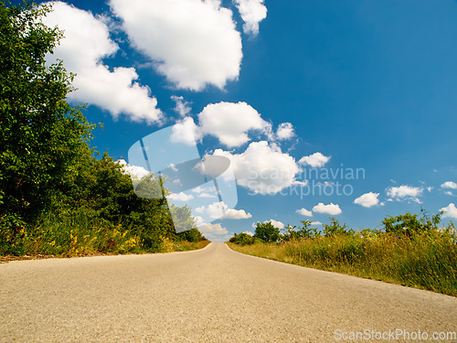 Image of Countryside road, outdoor landscape and sky with clouds, summer sunshine and background in nature. Street, asphalt and spring with mockup space, trees and plants from low angle in natural environment