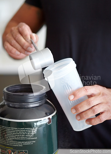 Image of Man, hands and preparing protein shake for nutrition, muscle gain or body mass product and supplement. Hand of male bodybuilder making pre workout or powder drink for exercise or healthy meal at home