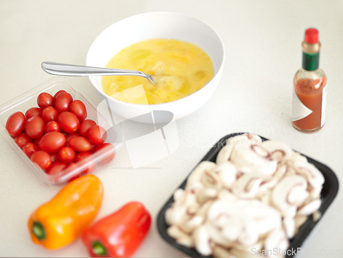 Image of Cooking preparation, ingredients and breakfast on a counter for health, nutrition and protein. Kitchen, healthy and omelette food, eggs and product on a table in the morning ready to cook for diet