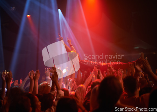 Image of Crowd surf, light and people at music festival, neon lights and energy at live concert event. Dance, fun and group of excited fans in arena at rock show performance, audience carrying fan on hands.