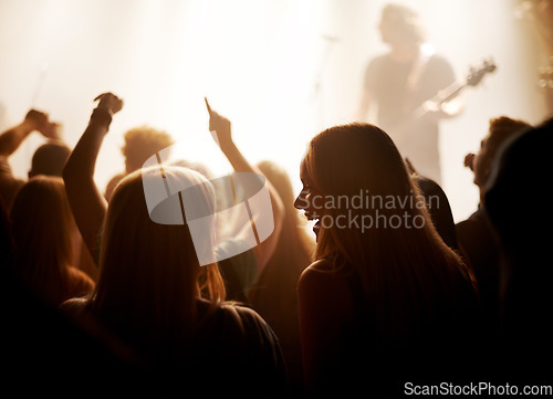 Image of Excited women, friends and fans at music festival, lights and crowd in silhouette at live band performance on stage. Happiness, people with smile and lighting, excitement at rock concert together.
