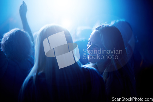 Image of Smile, women in crowd at music festival and blue lighting, happiness at live concert event. Dance, fun and group of excited, fans in arena at rock band performance or happy woman and friends at party