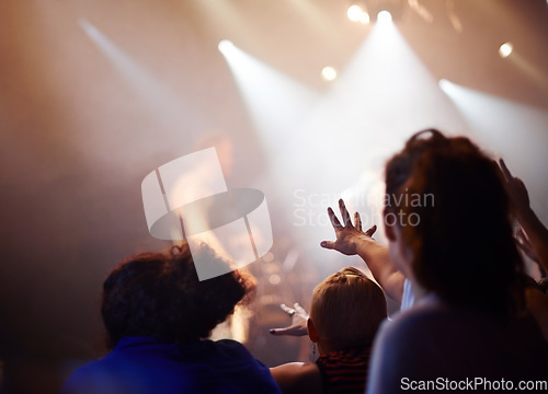 Image of Hands, lighting and excited fans at music festival, crowd watching live band performance with musician on stage. Happiness, excitement and audience in arena, woman fans with hand out at rock concert.