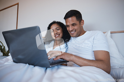 Image of Love, laptop and happy couple relax in bed, bonding and enjoying streaming, movie or browsing in their home. Online, film and man with woman in a bedroom for weekend, entertainment and subscription