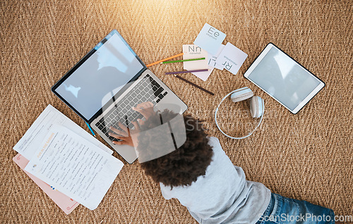 Image of Online education, laptop and child on floor for e learning, language translation and typing on kids website. Kid relax on carpet with computer, headphones and digital tech for home development above