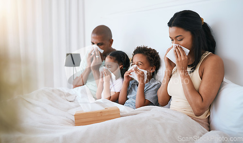 Image of Sick, flu and family on a bed, tissue and blowing nose with illness, disease and cold at home. Parents, mother and father with siblings, children and kids in a bedroom, allergy and health issue