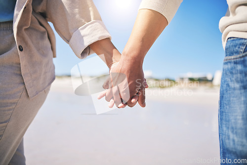 Image of Holding hands, love and a couple walking on the beach for romance, support or a date. Content, vacation and a man and woman with affection on a walk at the ocean for commitment and trust together