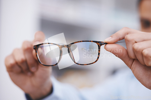 Image of Optometry, hands and optician with glasses for choice, eyesight and frame decision. Giving, showing and a man holding prescription eyewear for a fitting, vision and service during a consultation