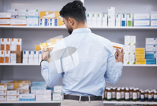 Image of Pharmacy, medicine and man with pills choice for medication, prescription and treatment. Healthcare clinic, drug store and male person reading boxes for medical product, supplements and antibiotics