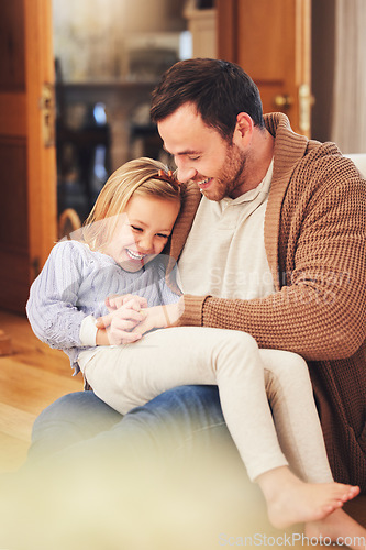 Image of Father, girl on lap and laughing in home, playing and bonding together. Dad, happiness and child or daughter laugh at funny joke, humor or comic comedy, having fun and enjoying quality time with care