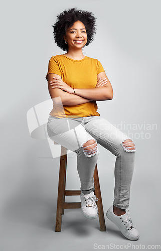 Image of Portrait, smile and woman with arms crossed on stool in studio isolated on a gray background. Chair, confidence and happy African female person from South Africa with stylish fashion, gen z or trendy