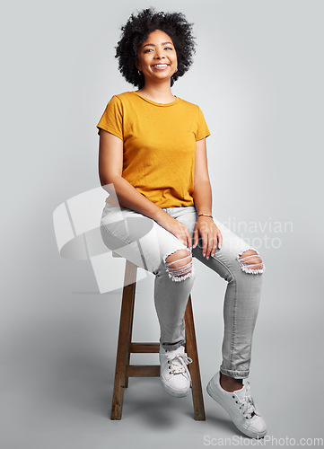 Image of Portrait, smile and woman sitting on stool in studio isolated on a white background. Chair, confidence and happy African female person from South Africa with stylish fashion, gen z or trendy clothing