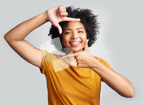 Image of Portrait, finger frame and happy woman in white background, studio and review profile picture. Face, young female model and hands to border perspective, cool selfie and smile for creative photography