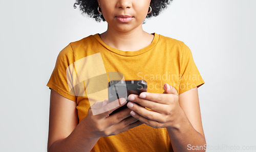 Image of Woman, hands and texting on cellphone in studio for notification, social media post and online chat. Closeup female model typing on smartphone, mobile app download and technology on white background