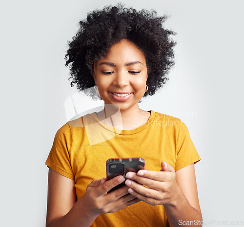 Image of Happy, woman and cellphone texting on white background of notification, social media post and online chat. Young african female model typing on smartphone, mobile app or download technology in studio