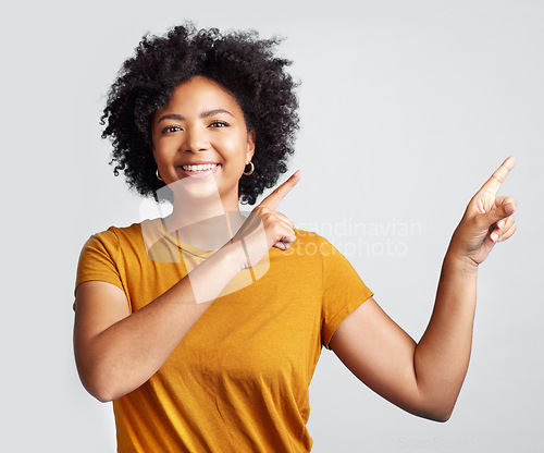 Image of Portrait of happy woman, advertising and pointing to studio offer, information and brand coming soon. African female model gesture to announcement, sales promotion or presentation on white background