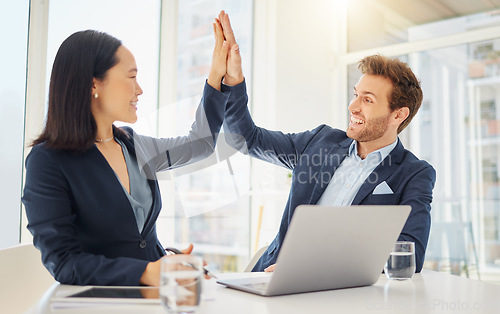 Image of Business man, woman and high five with laptop, partnership or motivation for teamwork in office. Japanese businesswoman, businessman and computer with diversity, support or celebration for goals