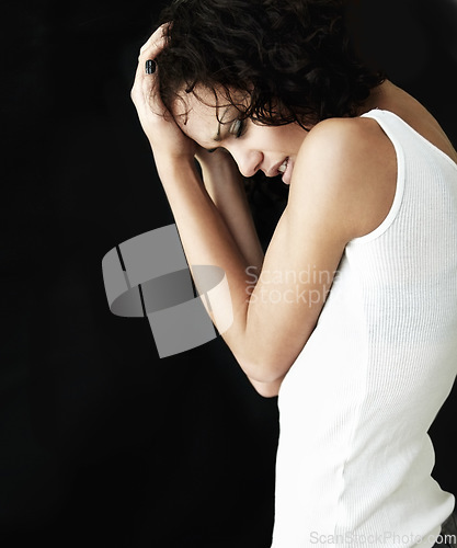 Image of Depressed, dark and woman with anxiety, bipolar or mental health problem isolated in a black studio background. Headache, pain and female person with depression, psychology issue or identity crisis