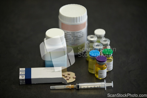 Image of Medicine container, pills and a syringe or needle on a table for healthcare. Steroids, medical aesthetics and supplements together for bodybuilder muscle growth for testosterone, nutrition and doping