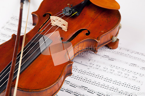 Image of Sheet, music and classical with violin on paper for orchestra, vintage and antique instrument. Notes, retro art and culture with closeup of wooden fiddle for symphony, sound and theatre performance