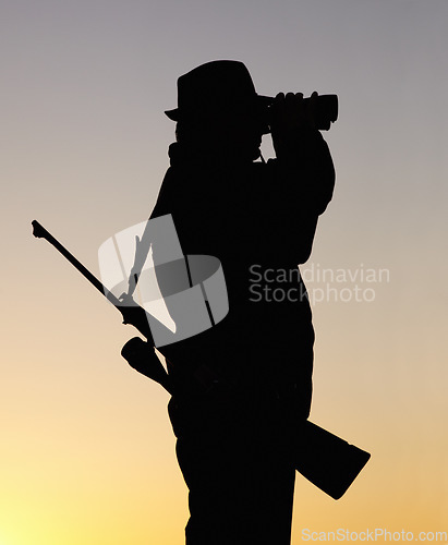 Image of Hunting at sunset, man with gun and binoculars in nature to hunt game for sport on safari adventure. Sky, silhouette and hunter with rifle, search and setting sun for shooting hobby on summer evening