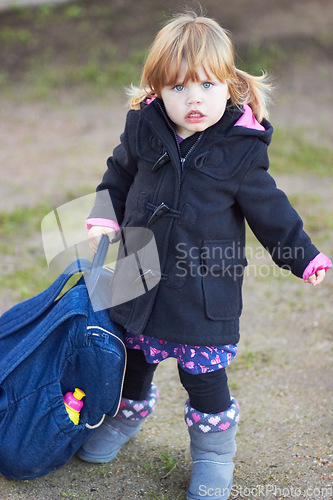 Image of Winter, fashion and portrait of baby in outdoor for cute, trendy and growth. Child development, sweet and style with young girl and backpack walking in park for urban, season and adorable