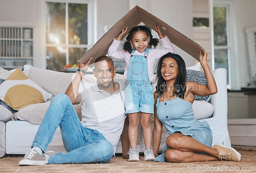 Image of Portrait, cardboard roof and family in the lounge, home insurance and care with protection, smile and safety. Face, parents or mother with father, girl and daughter in the living room, love and cover