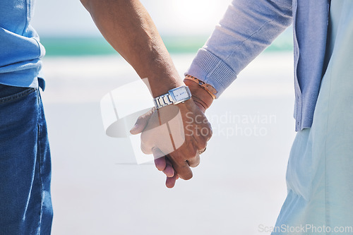 Image of Unity, love and couple holding hands at a beach with trust, solidarity and commitment in nature. Hand, care and man with woman on romantic walk at the sea, sweet and bonding while traveling together