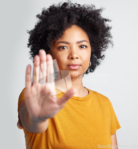 Image of Woman, stop and hand in studio portrait for human rights abuse, racism and afro by gray background. Girl model, gesture or activism for discrimination, justice or protest for freedom, peace or vote