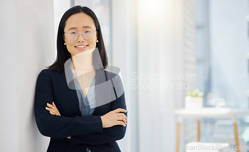 Image of Portrait and arms crossed with a business asian woman in her office for corporate success. Professional, mindset and vision with a confident young female employee standing in her workplace