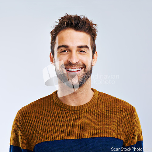 Image of Portrait, smile and man with positive, confidence and carefree against a grey studio background. Face, male person and human with a cheerful attitude, freedom and model with joy, Canada and relax