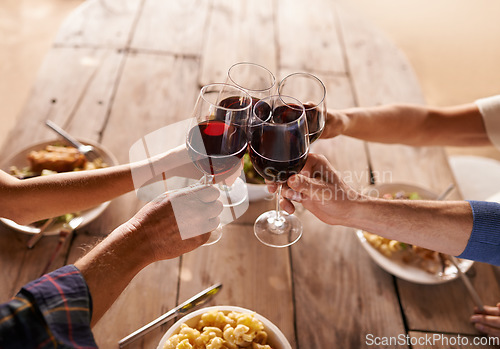 Image of Hands, group and wine glass for toast at table for celebration, food and friends at lunch event. People, together and celebrate with alcohol, glasses and support at party, dinner and family home