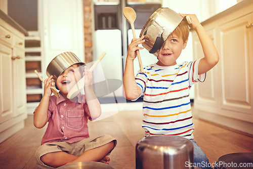 Image of Funny, pots and playing with children in kitchen for imagination, fantasy and games. Bonding, siblings and happy with kids and kitchenware on floor of family home for music, noise and happiness