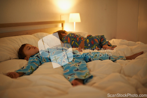 Image of Two brothers, sleeping and night in bed for rest together, peace and health in family home. Young tired kids, boy children and tired with calm sleep, fatigue and dream on blanket in bedroom at house