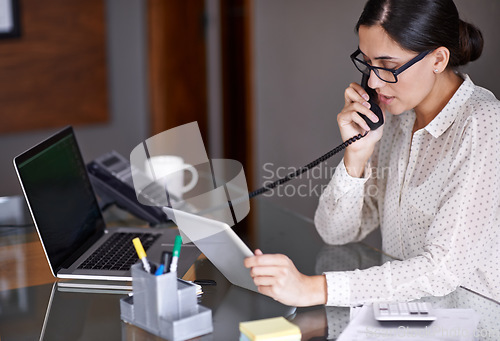 Image of Telephone, tablet and businesswoman on a call in the office doing research on the internet. Technology, landline and professional female employee working on corporate project with mobile in workplace