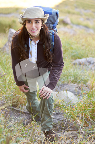 Image of Woman, hiking portrait and smile on mountain to start adventure, journey or fitness with backpack in nature. Girl hiker, walking or field with happiness for exercise in countryside, summer or outdoor