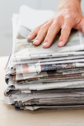 Image of Newspaper, sustainability and hand of man on stack for recycling, environment and resources. Eco friendly, waste and news with closeup of person and paper for responsibility, garbage and conservation