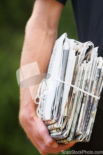 Image of Closeup, stack and man with newspaper, delivery and daily information with stories, courier and bundle. Zoom, male person and hand with journalism, recycle paper and distribution with sustainability