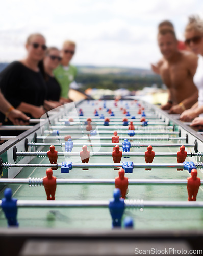 Image of Friends playing with a foosball at a party for competition, fun skill or sports event. Celebration, activity and group of people enjoying a football table game or match for a friendly championship.