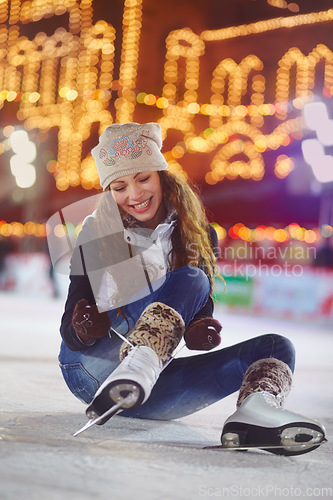 Image of Smile, ice skating and woman tie shoes on rink to start fitness, exercise and workout at night. Skater, happiness and female person tying skates for winter training, preparing and getting ready.