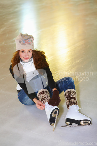 Image of Portrait, ice skating and woman tie shoes on rink to start fitness, exercise and workout at night. Skater, happiness and female person tying skates for winter training, getting ready and top view.