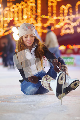 Image of Ice skating, happy and woman tie shoes on rink to start fitness, exercise and workout at night. Skater, smile and female person tying skate laces for winter training, preparing and getting ready.